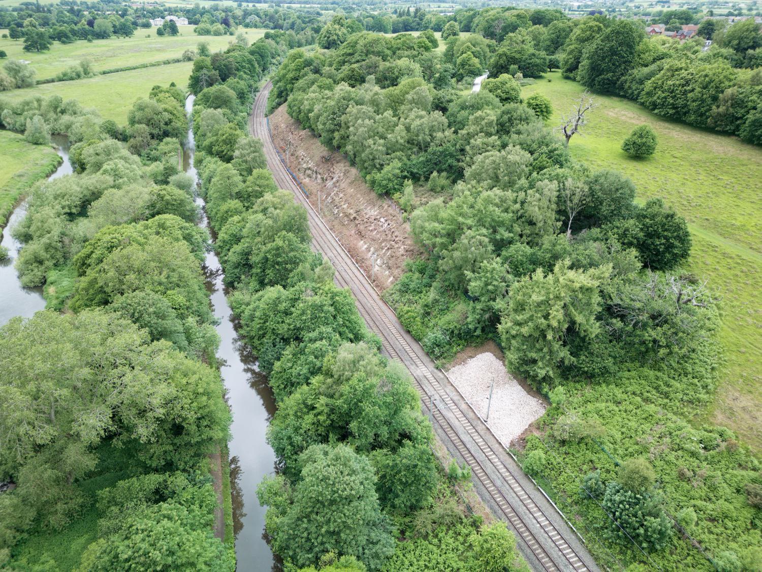 Aerial view of the railway line beside a canal and open countryside