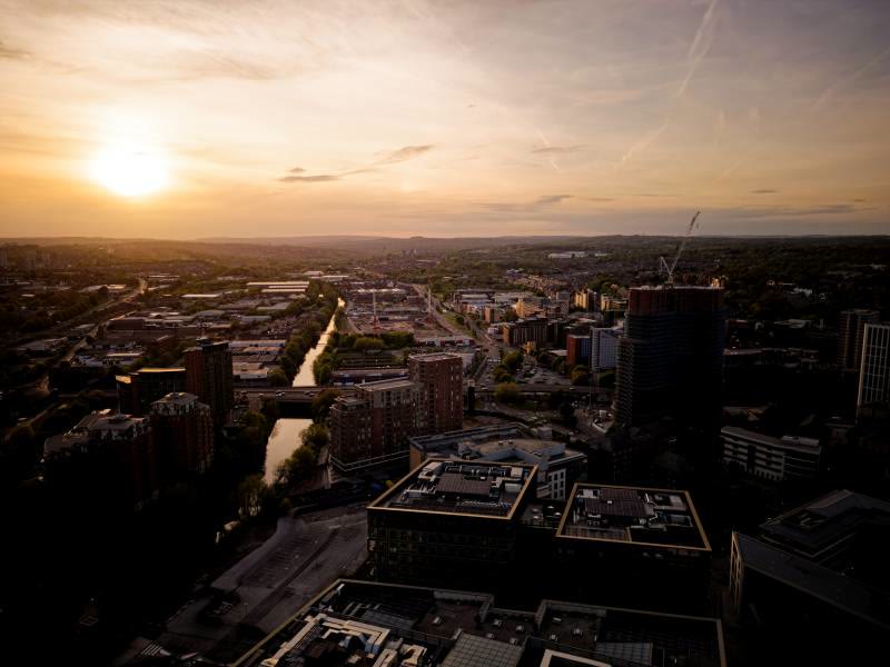 Aerial drone view over a UK city centre at sunset